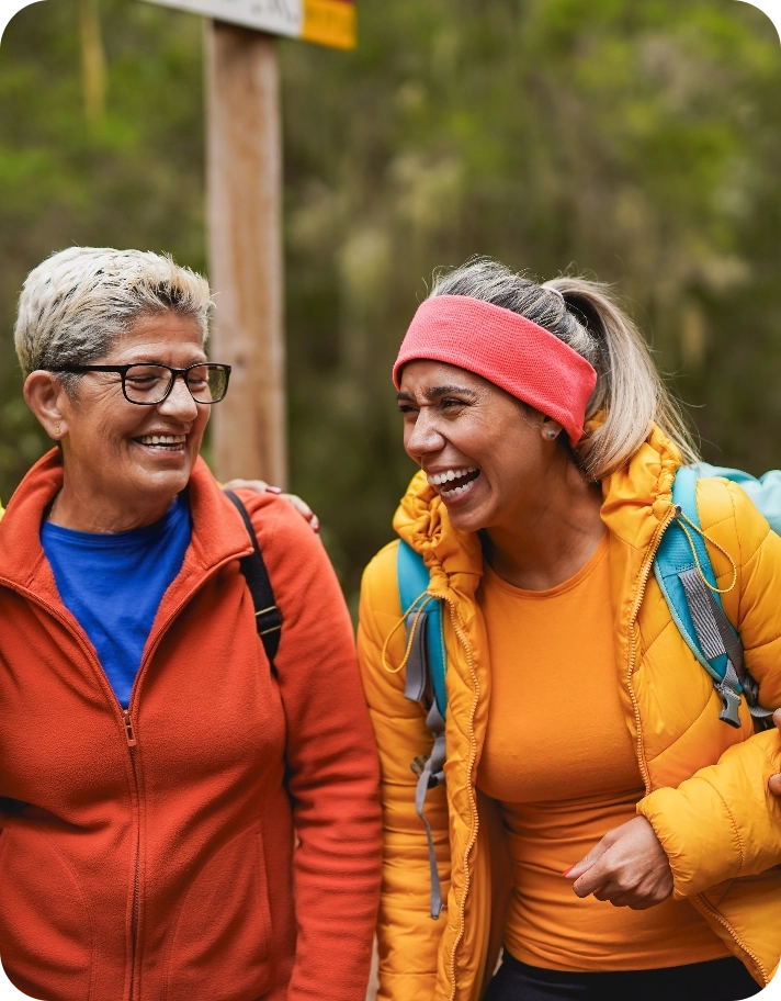 Two women laughing on a hike